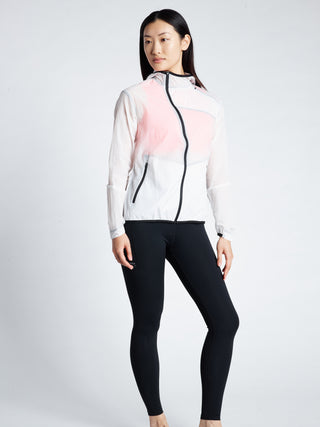 Woman wearing a TAGATONNA ATHLETIC DESIGN LAB white transparent  jacket with  and black leggings 