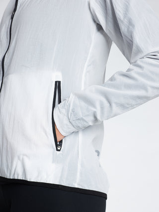 Woman wearing a white transparent TAGATONNA  jacket with a black zipper pocket 