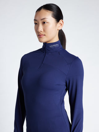 Woman wearing a blue long-sleeve minimalistic TAGATONNA  Mid Layer  with logo and shorts 